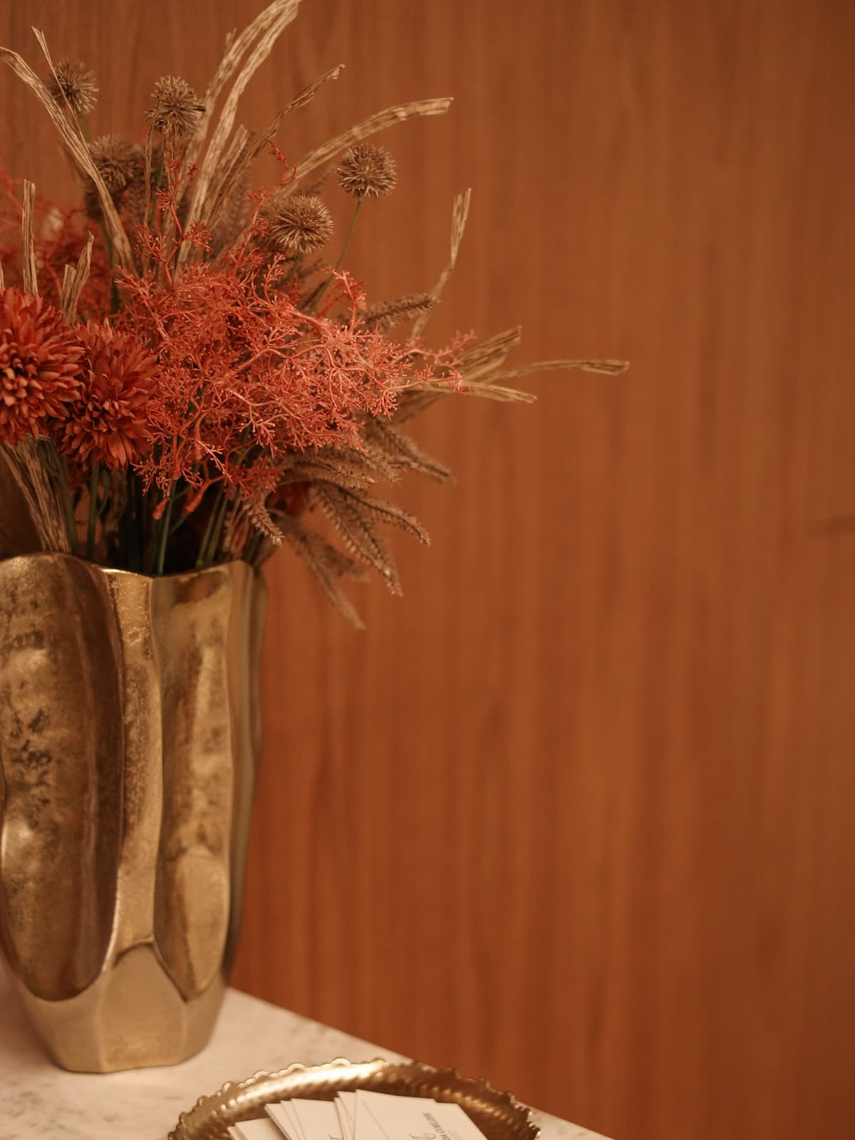 Vaso dourado com flores secas na recepção